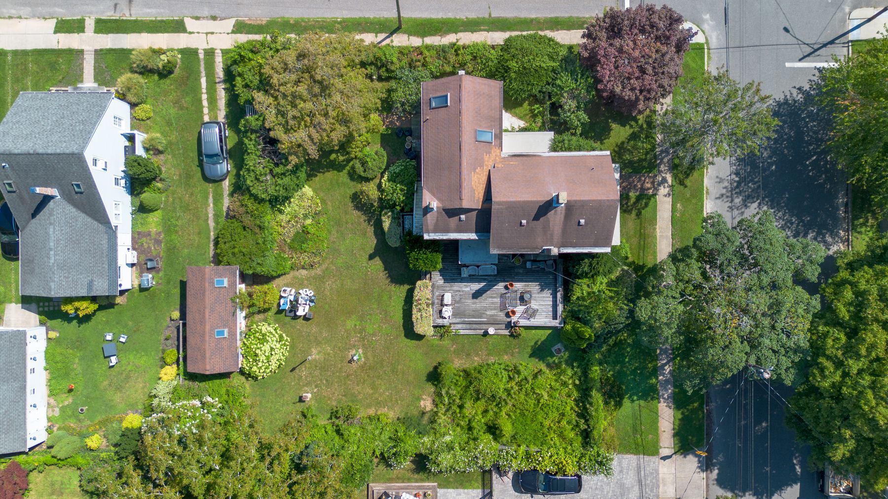 Looking straight down on the house, the deck, the detached garage, and the depth of the rear lawn